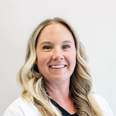 Family Nurse Practitioner Kresha Archuleta Smiling In Lab Coat